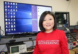 Photo of Jing Li in front of a large computer
